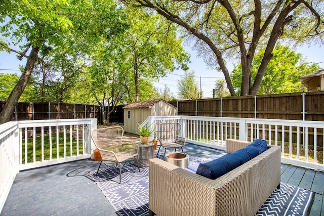 wooden terrace with a fenced backyard, an outdoor structure, and a storage shed