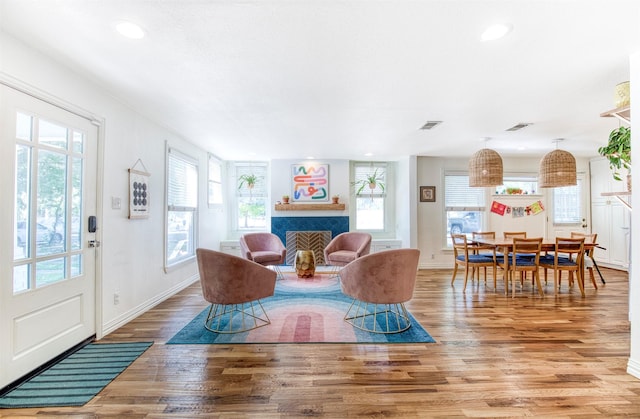 living room featuring wood finished floors, visible vents, and a healthy amount of sunlight