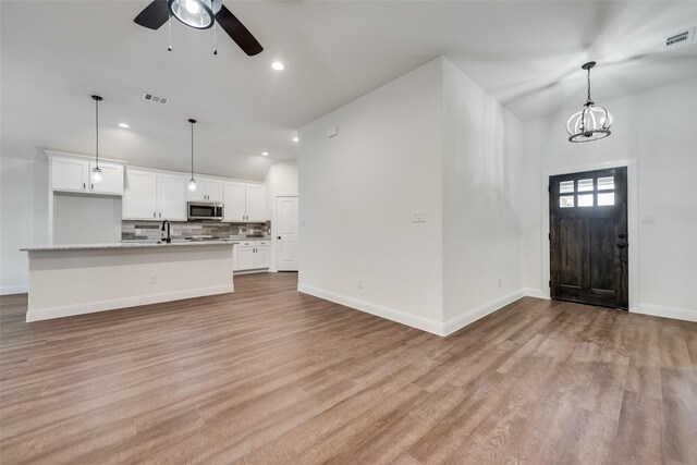 foyer featuring ceiling fan, baseboards, light wood finished floors, and recessed lighting