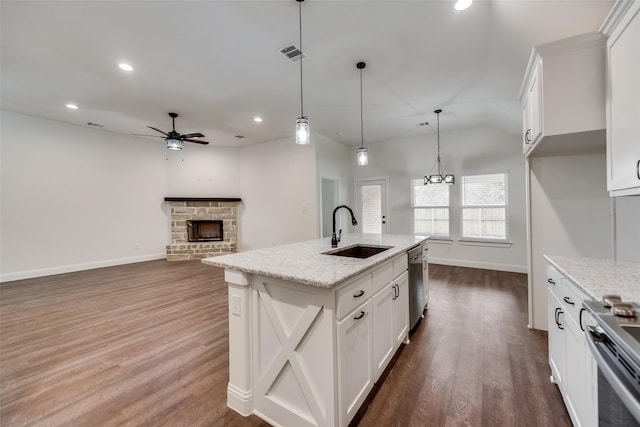 kitchen with a sink, dark wood finished floors, visible vents, a fireplace, and appliances with stainless steel finishes