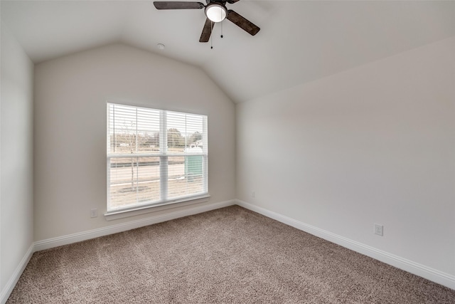 empty room featuring baseboards, vaulted ceiling, carpet flooring, and ceiling fan
