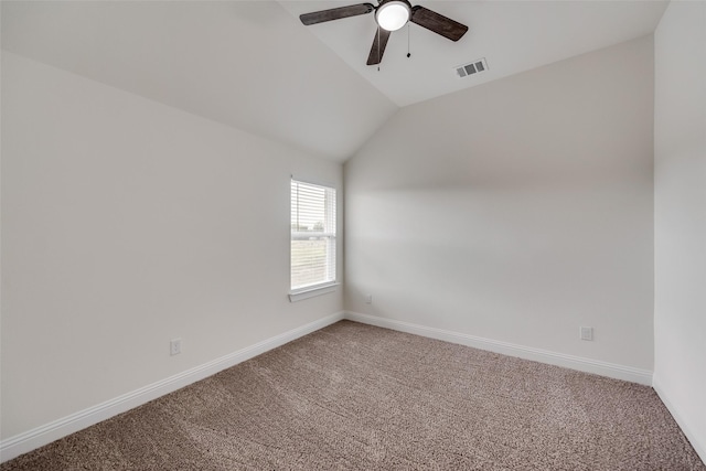 carpeted spare room with baseboards, a ceiling fan, visible vents, and vaulted ceiling