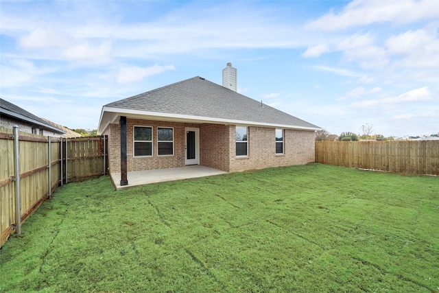 rear view of property featuring brick siding, a fenced backyard, a patio, and a chimney