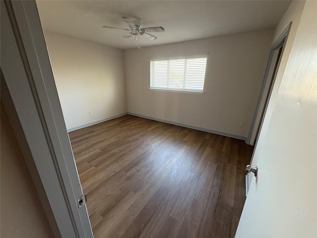 unfurnished bedroom featuring wood finished floors, a ceiling fan, and baseboards