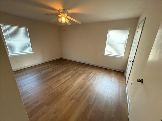 unfurnished room with baseboards, a ceiling fan, and wood finished floors