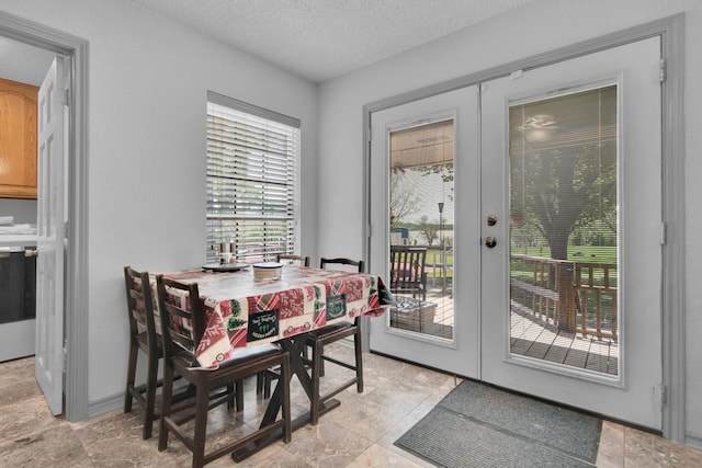entryway with a textured ceiling, stone finish flooring, and french doors