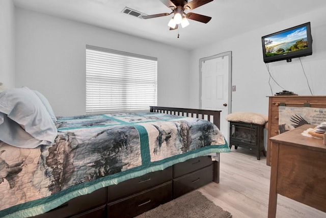 bedroom featuring light wood-style flooring, visible vents, and ceiling fan