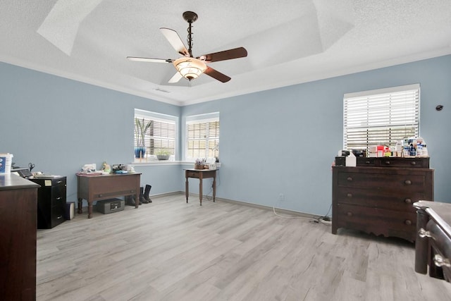 office space with visible vents, a ceiling fan, ornamental molding, light wood-style flooring, and a textured ceiling