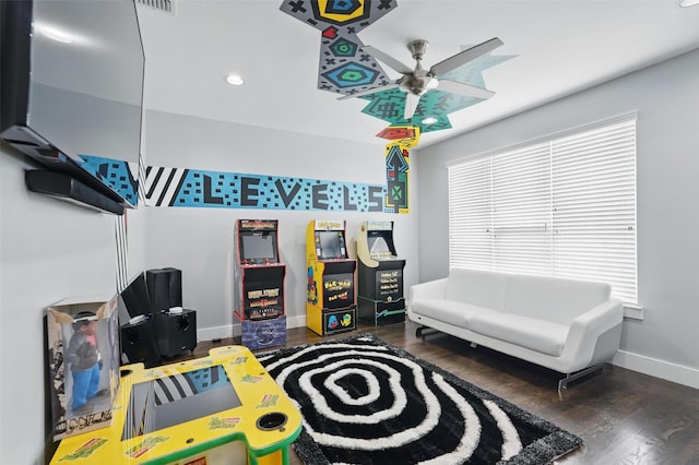 recreation room featuring wood finished floors, a wealth of natural light, a ceiling fan, and baseboards