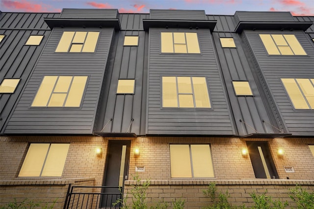 multi unit property with brick siding, board and batten siding, and fence