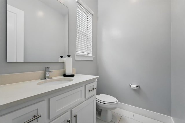 bathroom with tile patterned floors, baseboards, vanity, and toilet