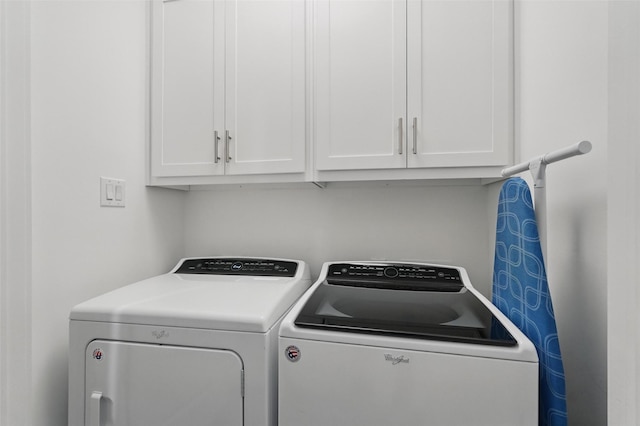 laundry room with independent washer and dryer and cabinet space