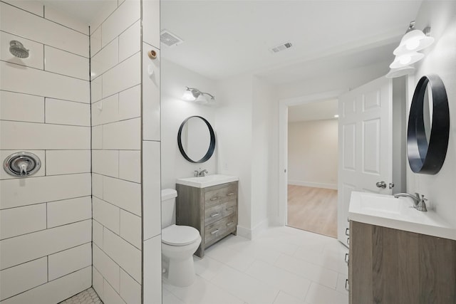 bathroom featuring tile patterned flooring, toilet, vanity, and visible vents