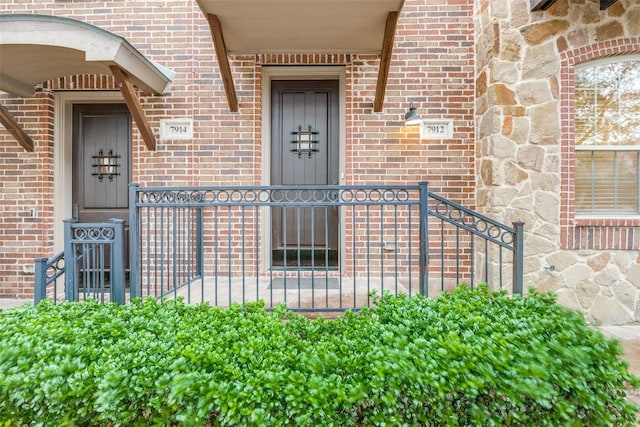 property entrance with brick siding and stone siding