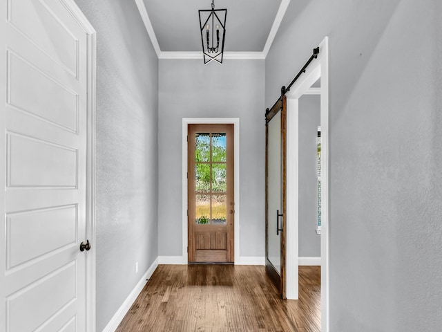 117 Fan Mill Trl, Weatherford, TX 76085 - entrance foyer with a barn door, wood finished floors, an inviting chandelier, baseboards, and ornamental molding