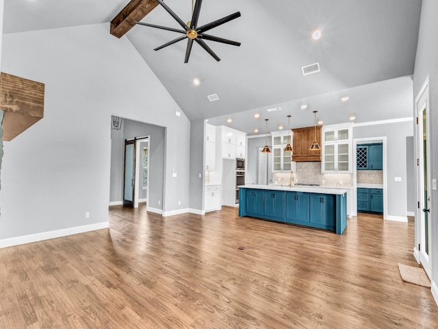 117 Fan Mill Trl, Weatherford, TX 76085 - unfurnished living room featuring high vaulted ceiling, a barn door, a ceiling fan, beamed ceiling, and recessed lighting
