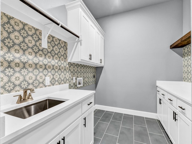 117 Fan Mill Trl, Weatherford, TX 76085 - clothes washing area featuring a sink, hookup for a washing machine, baseboards, dark tile patterned flooring, and cabinet space