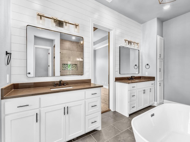 117 Fan Mill Trl, Weatherford, TX 76085 - bathroom featuring two vanities, a soaking tub, tile patterned floors, and a sink