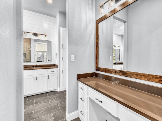 117 Fan Mill Trl, Weatherford, TX 76085 - full bath with two vanities, a textured wall, tile patterned floors, and a sink