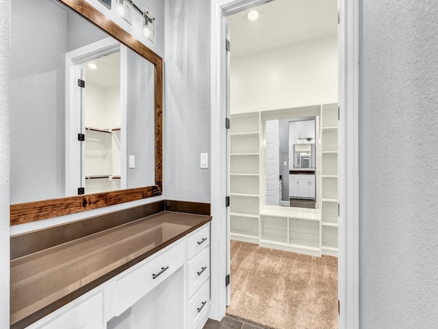 117 Fan Mill Trl, Weatherford, TX 76085 - bathroom with a spacious closet, a textured wall, and vanity