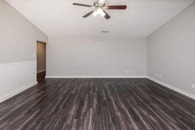empty room featuring lofted ceiling, wood finished floors, visible vents, a ceiling fan, and baseboards