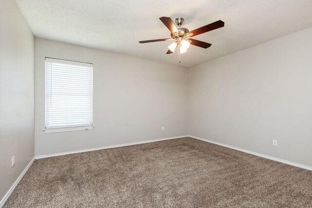 empty room with baseboards, a ceiling fan, carpet flooring, and a textured ceiling