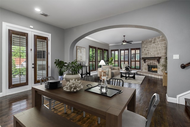 dining room with baseboards, wood finished floors, visible vents, and arched walkways