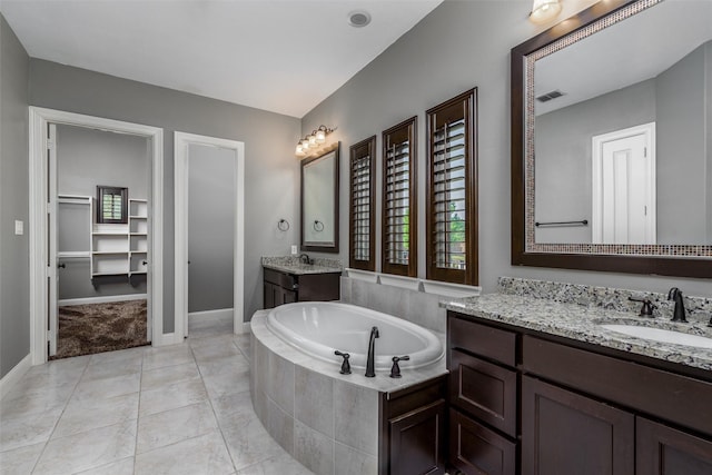 bathroom featuring a garden tub, visible vents, a sink, and a healthy amount of sunlight