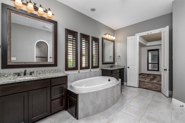 bathroom with baseboards, a garden tub, a sink, and plenty of natural light