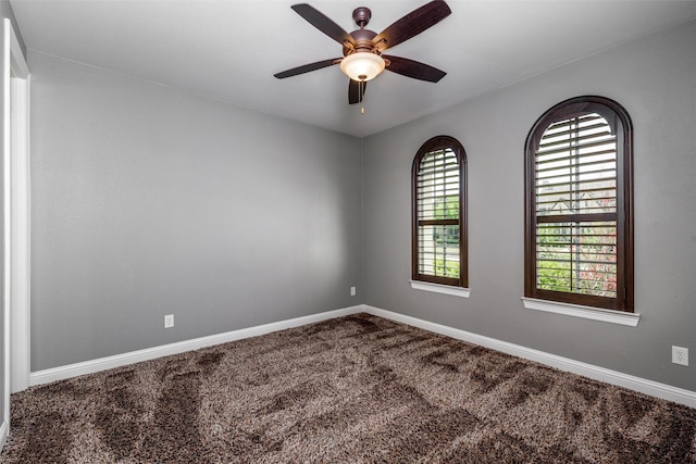 unfurnished room with carpet floors, a ceiling fan, and baseboards