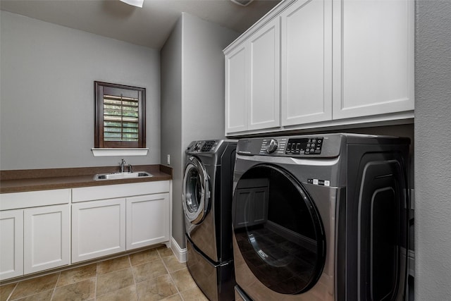 laundry area with washing machine and dryer, baseboards, a sink, and cabinet space
