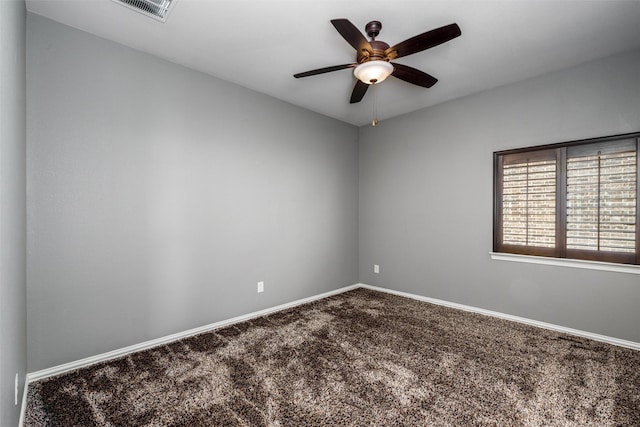 carpeted spare room featuring baseboards, visible vents, and ceiling fan
