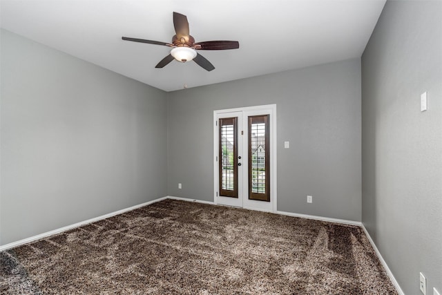 spare room featuring dark colored carpet, baseboards, and ceiling fan