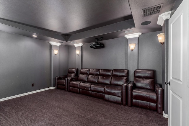 carpeted home theater room featuring visible vents, baseboards, and decorative columns