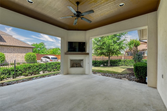 view of patio / terrace with an outdoor fireplace, fence, and a ceiling fan
