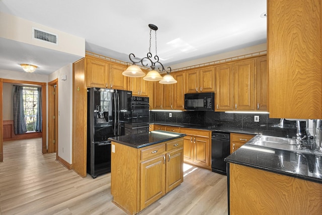 516 Wild Wood Dr, Decatur, TX 76234 - kitchen with black appliances, light wood finished floors, backsplash, a center island, and pendant lighting
