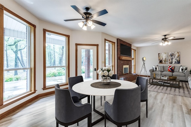516 Wild Wood Dr, Decatur, TX 76234 - dining space featuring ceiling fan, light wood-style floors, and a fireplace
