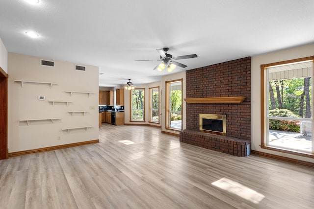 516 Wild Wood Dr, Decatur, TX 76234 - unfurnished living room featuring healthy amount of natural light, light wood finished floors, a ceiling fan, and a fireplace