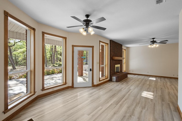 516 Wild Wood Dr, Decatur, TX 76234 - unfurnished living room with a ceiling fan, light wood finished floors, and a fireplace