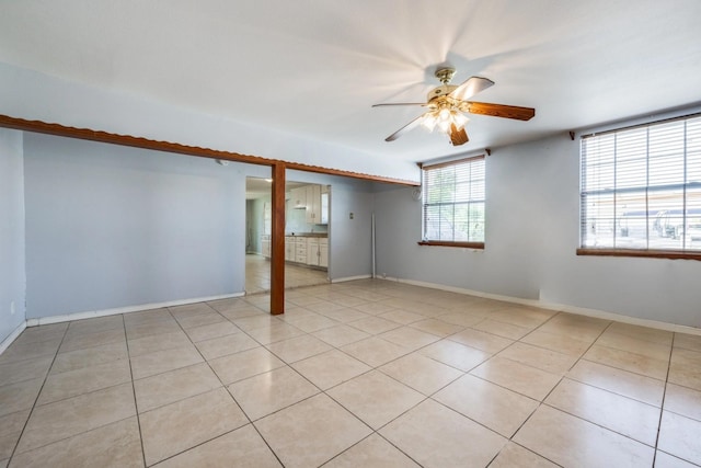 interior space with light tile patterned flooring, baseboards, and ceiling fan