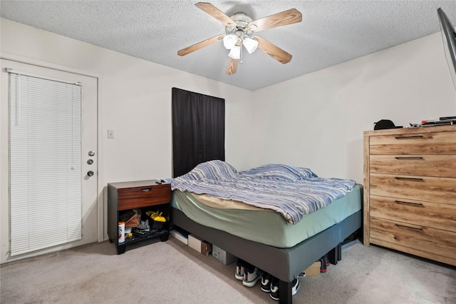 bedroom with a ceiling fan, carpet flooring, and a textured ceiling