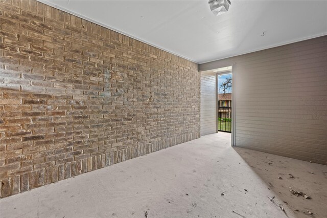 exterior space with brick wall and concrete flooring
