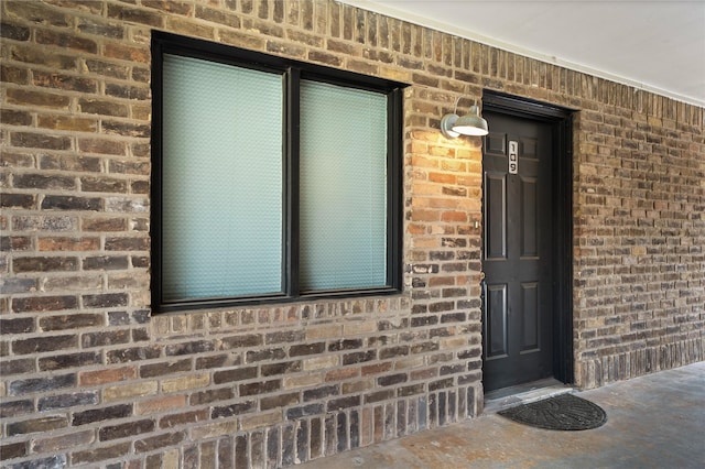 property entrance featuring brick siding