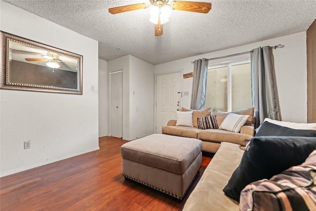 living room with wood finished floors, a textured ceiling, baseboards, and ceiling fan