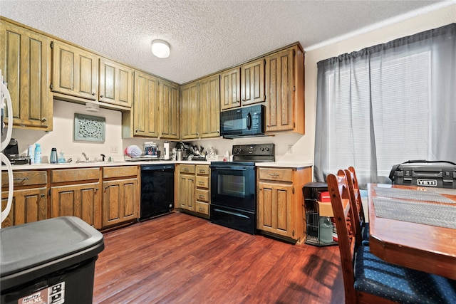 kitchen featuring light countertops, a textured ceiling, dark wood-type flooring, and black appliances