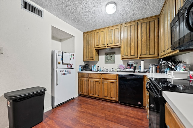 kitchen featuring black appliances, a sink, visible vents, and light countertops