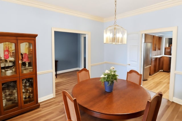 5021 Kenilworth Dr, Bossier City, LA 71112 - dining room with light wood finished floors, a chandelier, ornamental molding, and baseboards