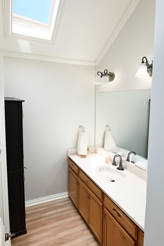 5021 Kenilworth Dr, Bossier City, LA 71112 - bathroom with vanity, a skylight, ornamental molding, wood finished floors, and baseboards