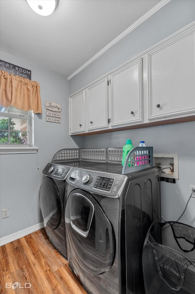5021 Kenilworth Dr, Bossier City, LA 71112 - laundry area featuring cabinet space, separate washer and dryer, light wood finished floors, crown molding, and baseboards