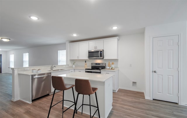 14151 Maida Dr, Pilot Point, TX 76258 - kitchen with a peninsula, light wood-style flooring, a sink, light countertops, and appliances with stainless steel finishes